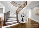 Elegant staircase with hardwood treads, white risers, and wrought iron balusters at 1311 Sunnys Halo Ln, Waxhaw, NC 28173