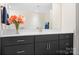 Bathroom with modern vanity and black cabinetry, neutral countertop and decorative flowers at 14015 Cameryn Elise Dr, Cornelius, NC 28031