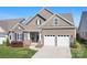 Charming home with a two-car garage, stone accents, and manicured lawn at 14015 Cameryn Elise Dr, Cornelius, NC 28031