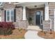 Inviting front porch with stone accents, well-manicured landscaping, and an attractive entryway at 14015 Cameryn Elise Dr, Cornelius, NC 28031
