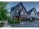 Modern home exterior with sleek dark siding, a pergola, and well-maintained landscaping at 1505 Landis Ave, Charlotte, NC 28205