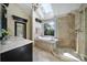 Luxurious bathroom with a soaking tub, glass-enclosed shower, skylight, and elegant fixtures at 15101 Sharrow Bay Ct # 12, Huntersville, NC 28078