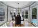 Bright breakfast nook with table and chairs surrounded by windows offering a view of the backyard pool at 15101 Sharrow Bay Ct # 12, Huntersville, NC 28078