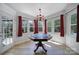 A sunlit game room features hardwood floors, large windows, and a unique game table at 15101 Sharrow Bay Ct # 12, Huntersville, NC 28078