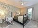 Bedroom features a leafy wallpaper accent wall, and large windows providing natural light at 1615 Merry Oaks Rd # G, Charlotte, NC 28205