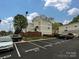 Apartment complex with reserved parking spaces on a sunny day with blue sky and fluffy clouds at 1615 Merry Oaks Rd # G, Charlotte, NC 28205