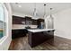 Kitchen showcasing stainless steel appliances, an island with bar seating, and dark wood cabinetry at 1976 Ethan Ln, Stanfield, NC 28163