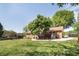 Expansive backyard featuring mature trees, a well-kept lawn, and patio seating area next to the brick home at 2064 Elizabeth Ave, Hickory, NC 28602