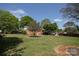 Large backyard with green lawn and trees, and the rear of a brick home at 2064 Elizabeth Ave, Hickory, NC 28602