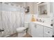 A clean bathroom with white vanity, toilet, and shower with decorative curtain; featuring light wood-look flooring at 2064 Elizabeth Ave, Hickory, NC 28602