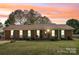 Charming brick home with a cozy front porch and well-manicured lawn under a vibrant sunset sky at 2064 Elizabeth Ave, Hickory, NC 28602