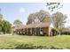 Single-story brick home with a well-maintained lawn, mature trees, and a covered porch at 2064 Elizabeth Ave, Hickory, NC 28602