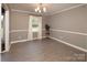 Bright living room features wood-look flooring, modern light fixture, and picture window bringing in lots of natural light at 2064 Elizabeth Ave, Hickory, NC 28602