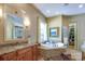 Luxurious bathroom featuring a soaking tub, granite countertops, and a large walk-in closet for ample storage at 2504 White Thorne Ln, Waxhaw, NC 28173