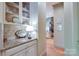 Charming butler's pantry with granite countertops, decorative backsplash, and glass-front cabinets for elegant storage at 2504 White Thorne Ln, Waxhaw, NC 28173