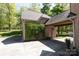 Attached brick carport with green vines and a door leading inside on a sunny day at 2504 White Thorne Ln, Waxhaw, NC 28173