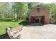 Detached brick garage with open doors and concrete driveway in a wooded, landscaped backyard at 2504 White Thorne Ln, Waxhaw, NC 28173