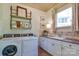 Well-equipped laundry room featuring a washer, dryer, ample counter space, and storage cabinets for convenience at 2504 White Thorne Ln, Waxhaw, NC 28173