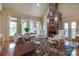 Cozy living room with a stone fireplace, vaulted ceilings, and hardwood floors at 2504 White Thorne Ln, Waxhaw, NC 28173
