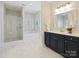Bright bathroom featuring a soaking tub, a glass shower, and a double sink vanity at 3005 Somerset Dr, Charlotte, NC 28209