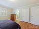 Bedroom showcasing hardwood floors, neutral walls, and a glimpse into the en-suite bathroom at 3005 Somerset Dr, Charlotte, NC 28209