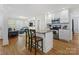 Open-concept kitchen with an island, white cabinetry, and modern appliances at 3005 Somerset Dr, Charlotte, NC 28209