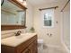 Bathroom boasts a vanity with a wood cabinet, a neutral countertop, and a framed mirror at 313 E Church St, Stanley, NC 28164