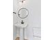 Bathroom featuring a pedestal sink, round mirror, and modern fixtures, offering a clean and simple design at 3433 Byrnes St, Charlotte, NC 28205
