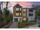 Modern home showcasing a mix of materials, including wood, gray siding, and black windows for an eye-catching facade at 3433 Byrnes St, Charlotte, NC 28205