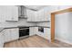 Contemporary kitchen features white cabinets, herringbone backsplash, stainless steel appliances, and hardwood floors at 3433 Byrnes St, Charlotte, NC 28205
