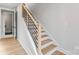 Modern staircase with wood steps and a sleek black railing, offering a bright and open transition between floors at 3433 Byrnes St, Charlotte, NC 28205