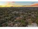 A scenic aerial view captures a neighborhood with Charlotte's skyline in the distance during a vibrant sunset at 3437 Byrnes St, Charlotte, NC 28205