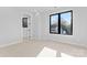 Bright bedroom featuring a large window, neutral carpet, and modern trim at 3437 Byrnes St, Charlotte, NC 28205