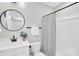 Bright bathroom with a modern vanity, round mirror, and a shower with patterned curtain at 3441 Byrnes St, Charlotte, NC 28205