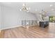 Open-concept living room and kitchen with modern finishes, hardwood floors, and a stylish light fixture at 3441 Byrnes St, Charlotte, NC 28205