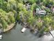 Aerial view showcasing the home's waterfront location and dock access, surrounded by lush greenery at 345 Porters Glen None, New London, NC 28127