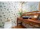 Stylish powder room with a unique wooden vanity and attractive bird-themed wallpaper at 345 Porters Glen None, New London, NC 28127