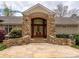 Grand front entrance featuring a custom wood door, stone accents, and elegant landscaping at 345 Porters Glen None, New London, NC 28127
