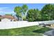 Backyard view features an expanse of green lawn enclosed by a white privacy fence and a brick patio at 3701 Arthur St, Indian Trail, NC 28079