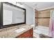 Bathroom featuring granite countertop, large mirror, and shower with tile surround at 3701 Arthur St, Indian Trail, NC 28079