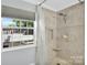 Bathroom with updated shower, window and neutral tile design at 3701 Arthur St, Indian Trail, NC 28079