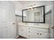 Bathroom boasting a dual sink vanity with framed mirror and stylish patterned walls at 4001 Brook Valley Run, Monroe, NC 28110