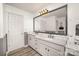 Elegant bathroom featuring a double sink vanity with modern fixtures, a large mirror, and sleek wood-look flooring at 4001 Brook Valley Run, Monroe, NC 28110