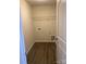 Functional laundry room with wood-look flooring, utility connections, and practical shelving for storage at 436 Phifer Rd, Kings Mountain, NC 28086