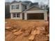 Two-story home featuring an attached two-car garage and red shutters, set against a natural backdrop at 438 Phifer Rd, Kings Mountain, NC 28086
