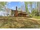 Backyard featuring a wooden deck, a brick chimney, and mature trees at 4896 Birch Cir, Hickory, NC 28602