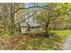 Quaint home with a welcoming front porch nestled within a lush, wooded landscape with a green lawn at 4896 Birch Cir, Hickory, NC 28602