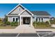 Exterior view of the gray clubhouse with a gated entrance and well-maintained landscaping for community enjoyment at 504 Cranford Dr, Pineville, NC 28134