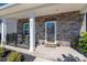 Cozy front porch featuring stone details, a seating area, and decorative plants at 504 Cranford Dr, Pineville, NC 28134