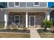 Inviting front porch with stone accents, seating area, and well-maintained landscaping at 504 Cranford Dr, Pineville, NC 28134